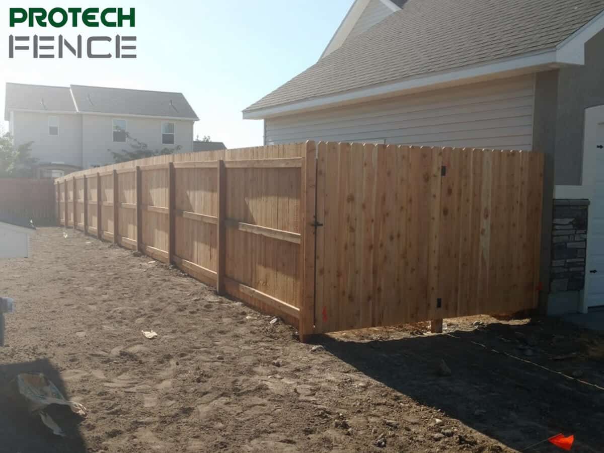 Newly installed wooden fence along a residential property, demonstrating the price per linear foot for wood fence installation.
