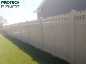 A professionally installed beige vinyl fence by Protech Fence, showcasing durability and privacy, representing quality affordable fence installation services in Ammon, Idaho.