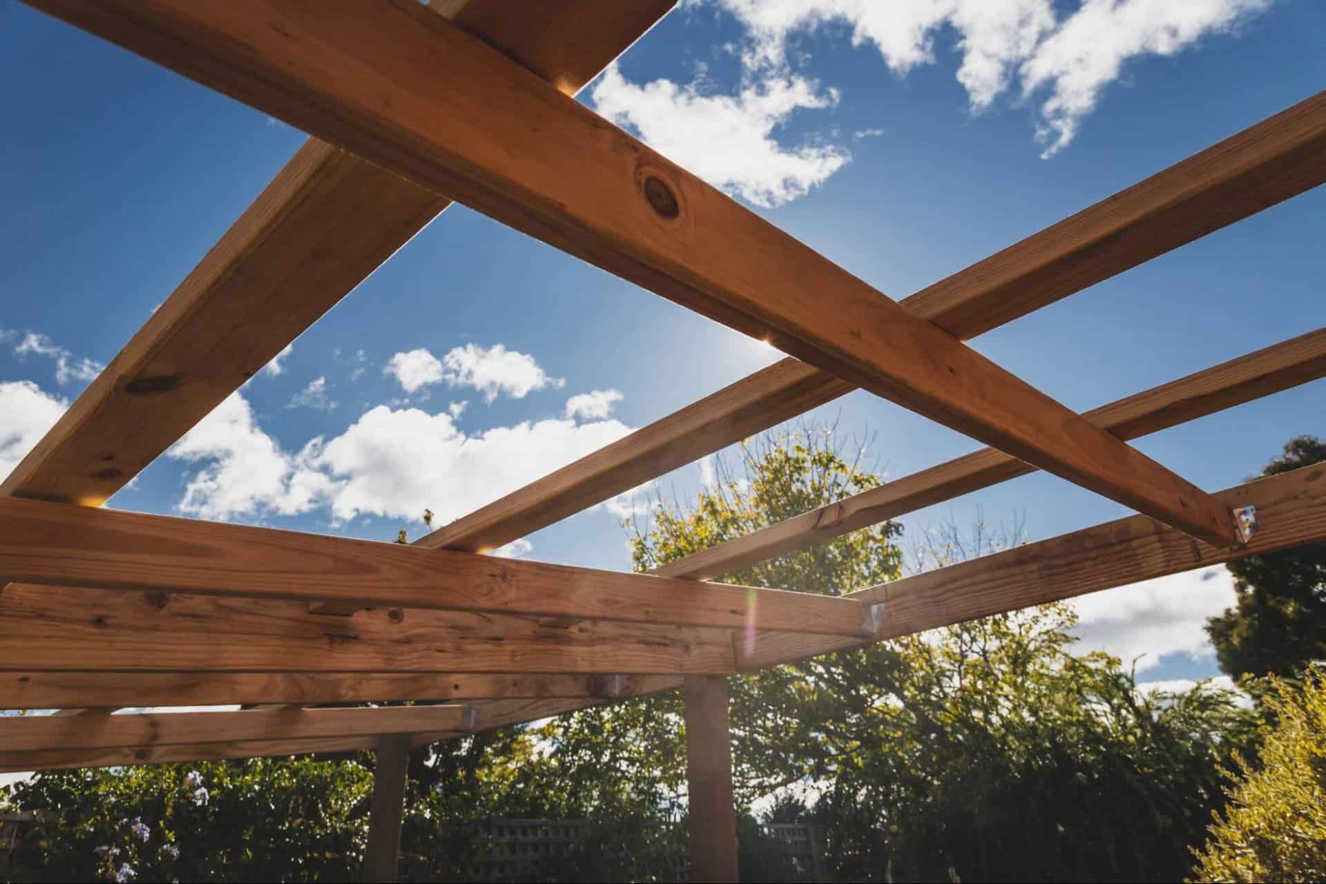 A wooden pergola frame under a sunny sky, ready for attaching shade cloth to provide effective sun protection and enhance outdoor comfort.
